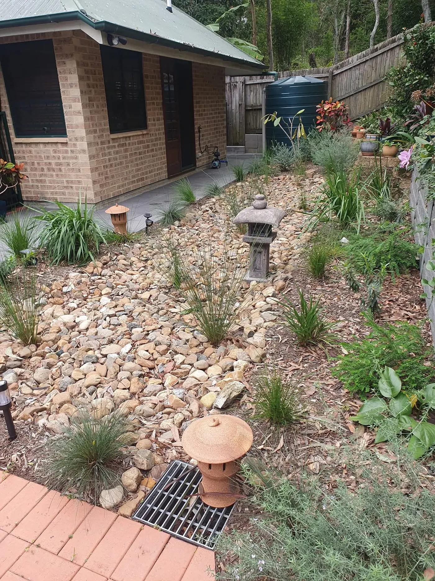 Japanese-inspired dry creek garden with river stones and native plantings