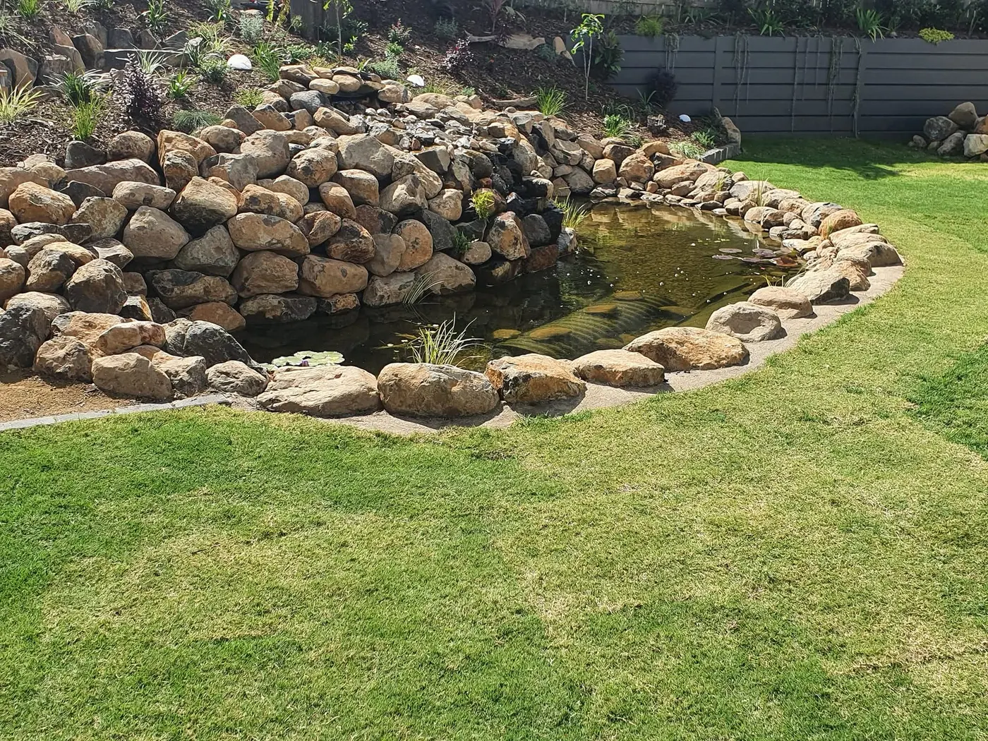 Stone waterfall cascading into pond